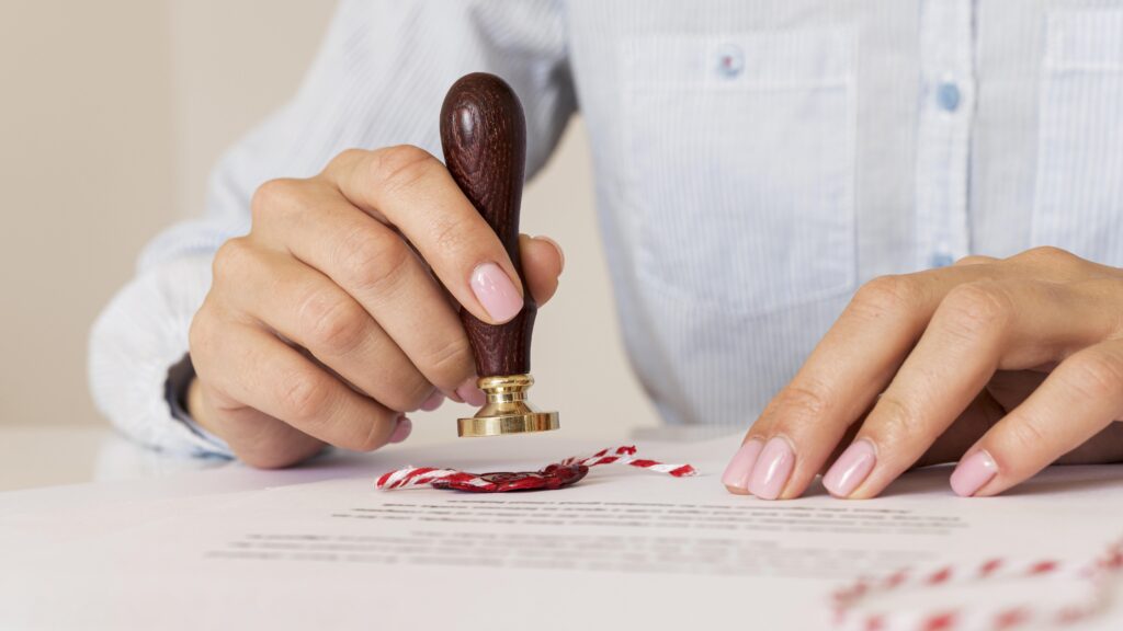 person-using-a-wax-seal-blurred-certificat
